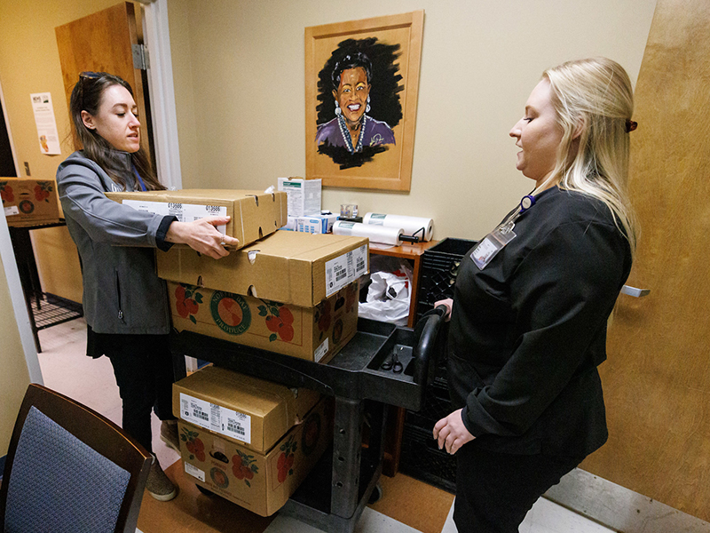 Butz, left, and UMMC researcher and student Kristen Dunaway, stock boxes and cans of food at the EversCare Clinic located at the Jackson Medical Mall.